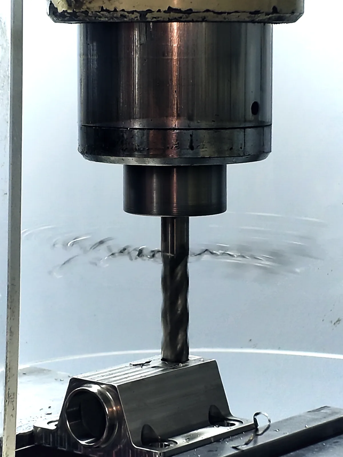 A drill running into a 316L stainless part under coolant on a five-axis machining center in Carson City