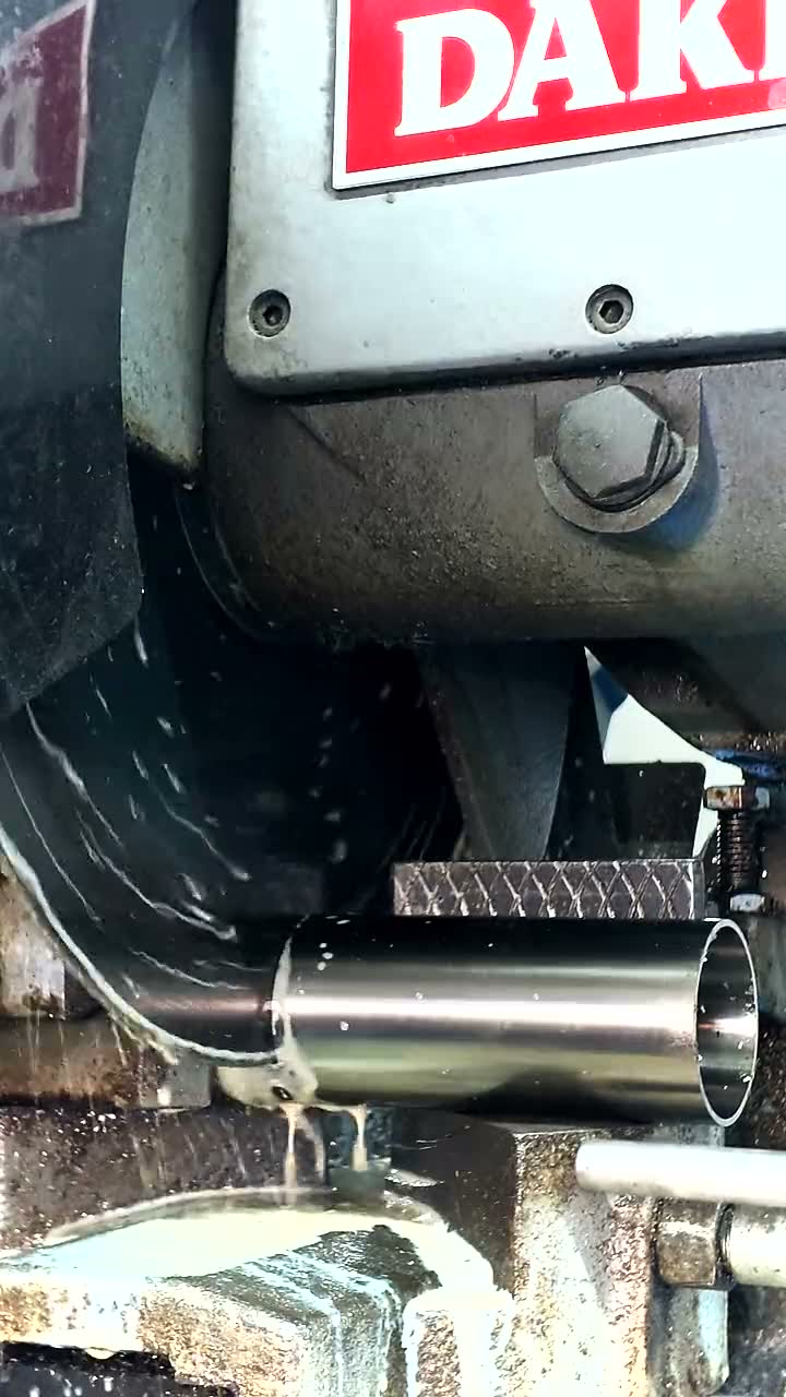 A stainless tube clamped in a cold saw, cut under flood coolant on the Carson City floor
