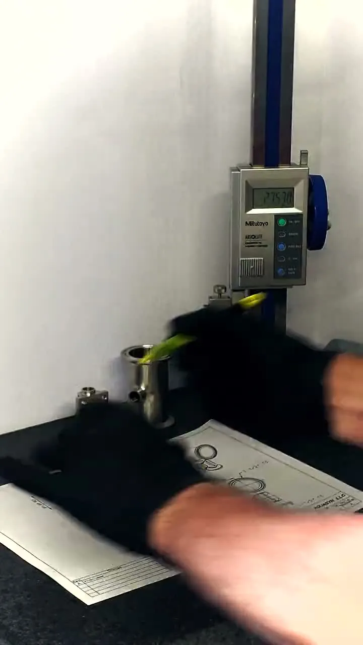 A digital height gauge measuring a stainless fitting on the inspection surface plate